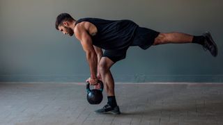 Man performs single-leg Romanian deadlift holding kettlebell