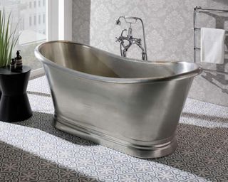 A small tin bathtub with patterned bathroom flooring and baroque style wallpaper