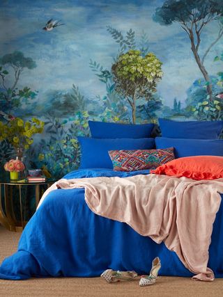 Blue bedroom with mural feature wall and bold blue bedding