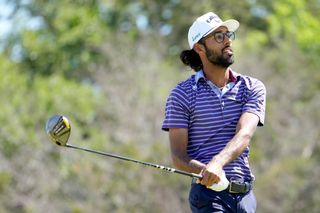 Akshay Bhatia hits a tee shot and watches the flight of it
