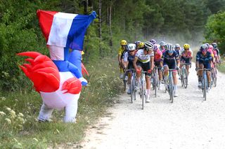 Elisa Balsamo of Italy and Team Trek- Segafredo leads the peloton through gravel roads while fans cheer during the 1st Tour de France Femmes 2022