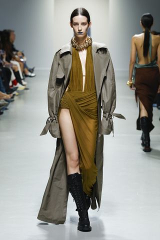 Atlein trägt ein khakifarbenes Kleid und einen Trenchcoat auf der Paris Fashion Week Frühjahr/Sommer 2025