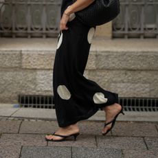 woman wearing polka dot skirt and heeled flip flops