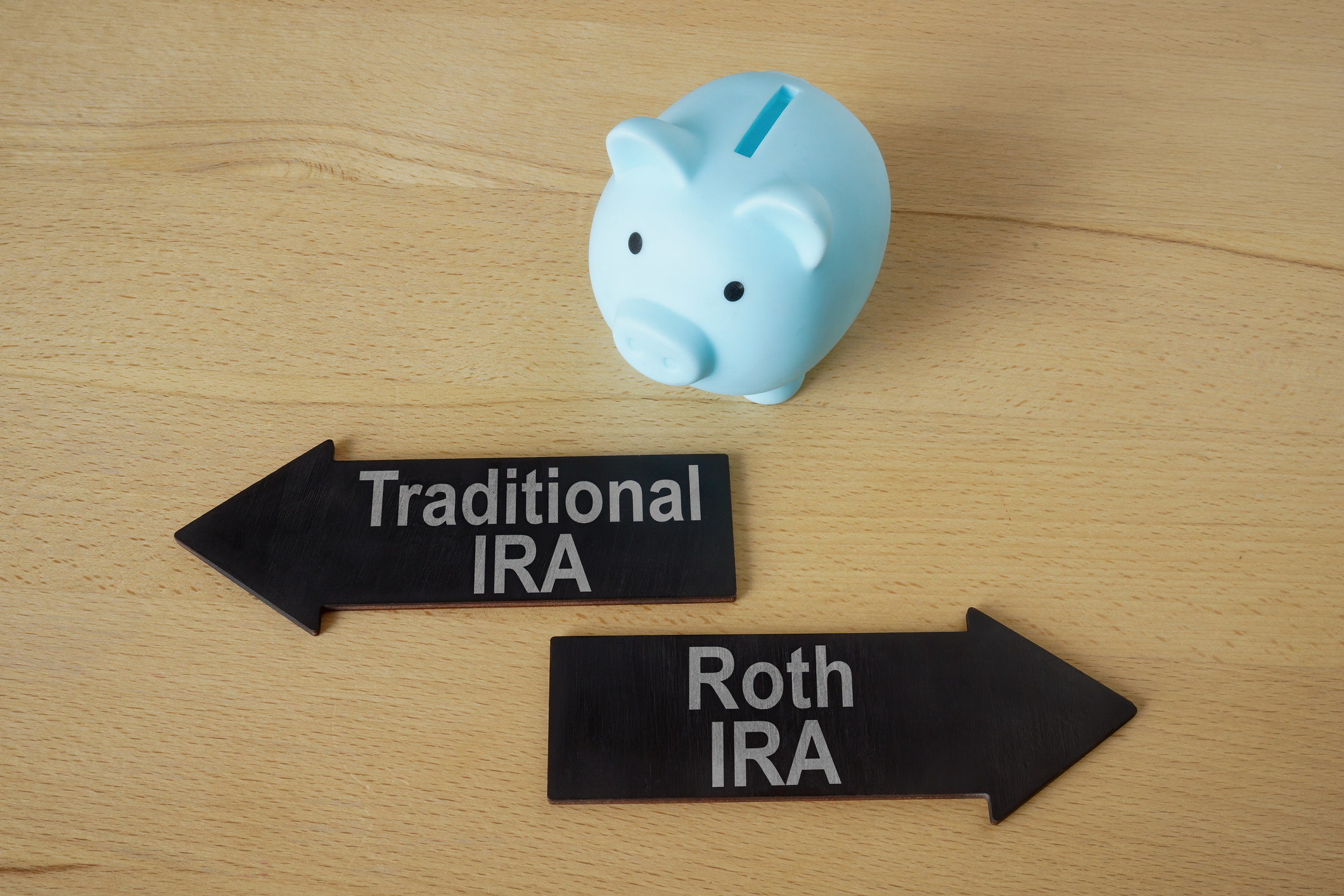 Piggy bank and arrows Traditional and Roth IRA.