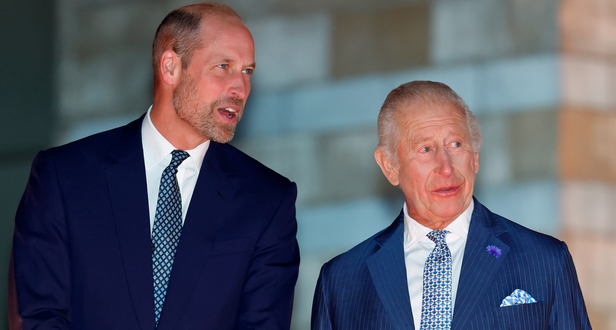 Prince William and King Charles talking in blue suits