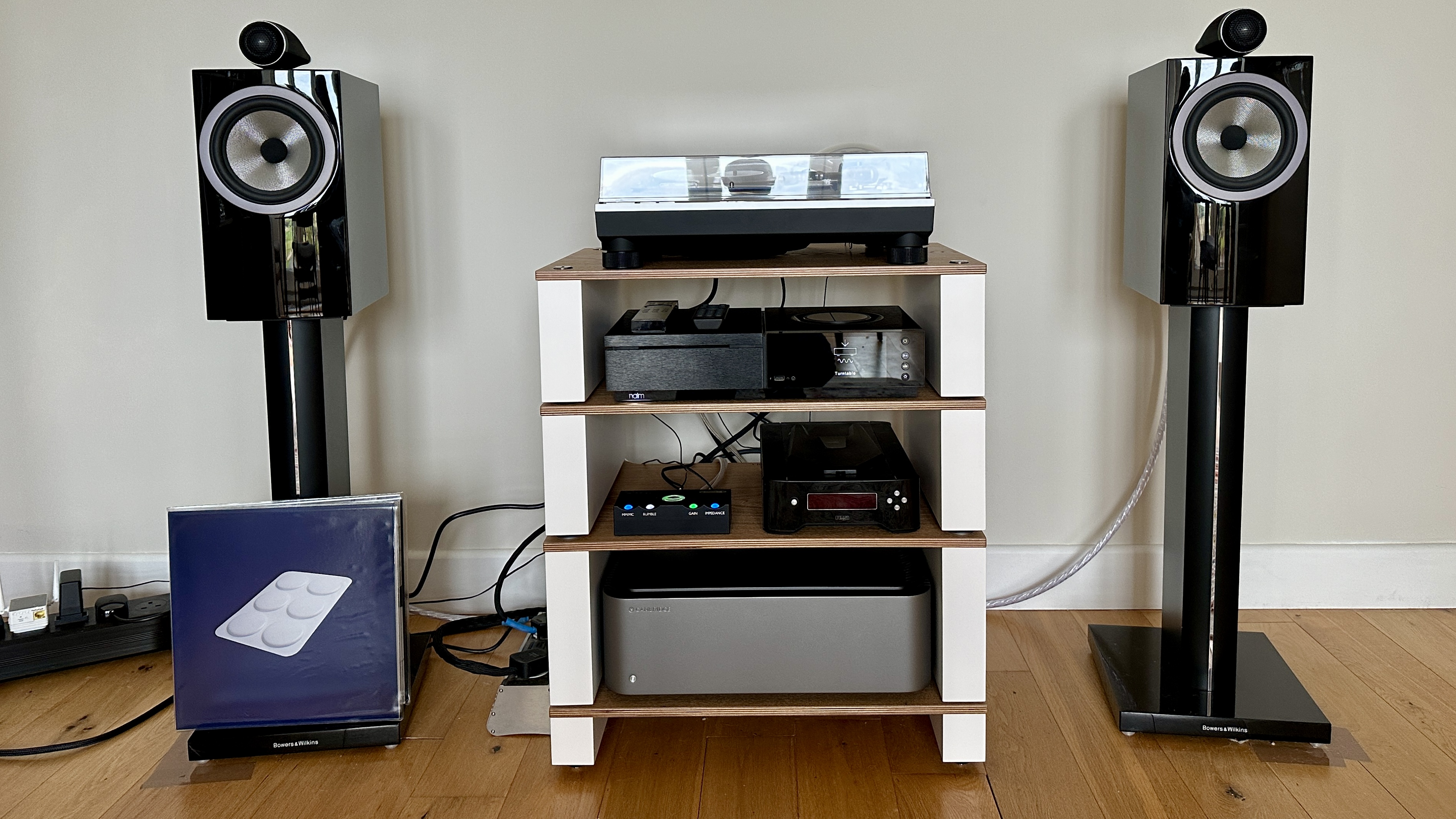 Technics SL-1300G turntable on top of a three-storey listening setup, with floor-standing speakers either side.