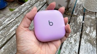 A Beats Fit Pro purple case held in the hand.