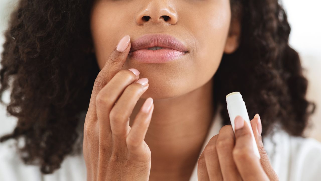 Close up of woman applying lip balm