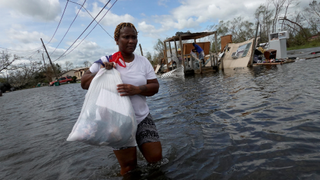 Woman walks through flooded street in Louisana