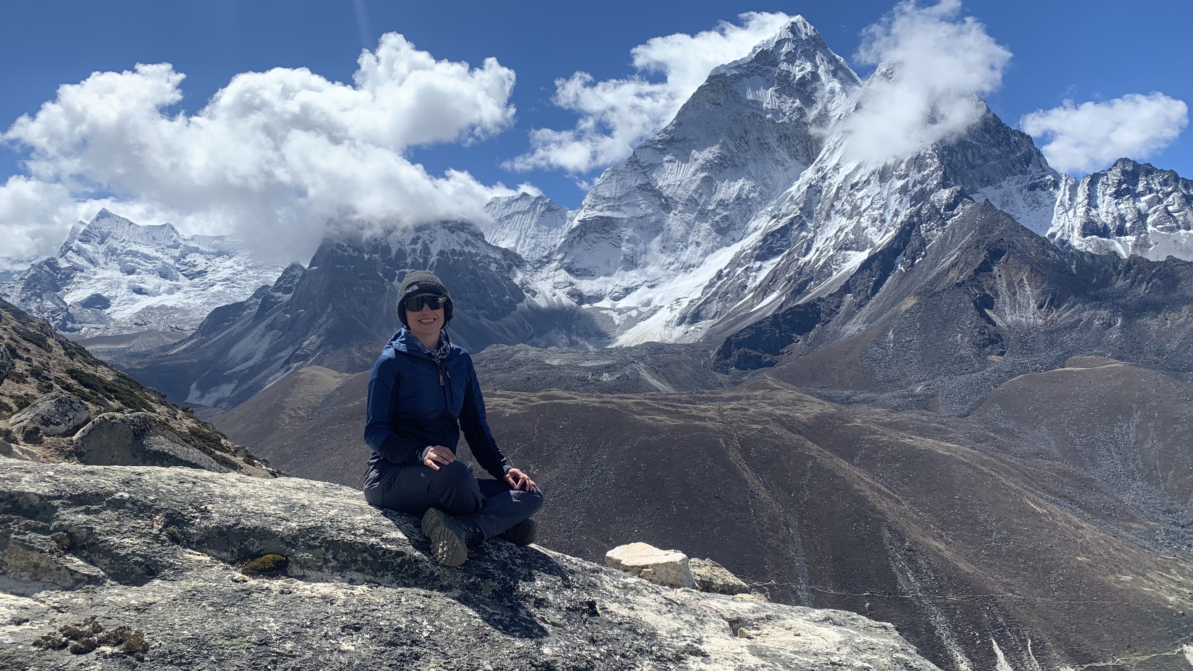 Julia Clarke in the Fjällraven Abisko Trail Fleece sitting on a rock on the trek to Everest Base Camp