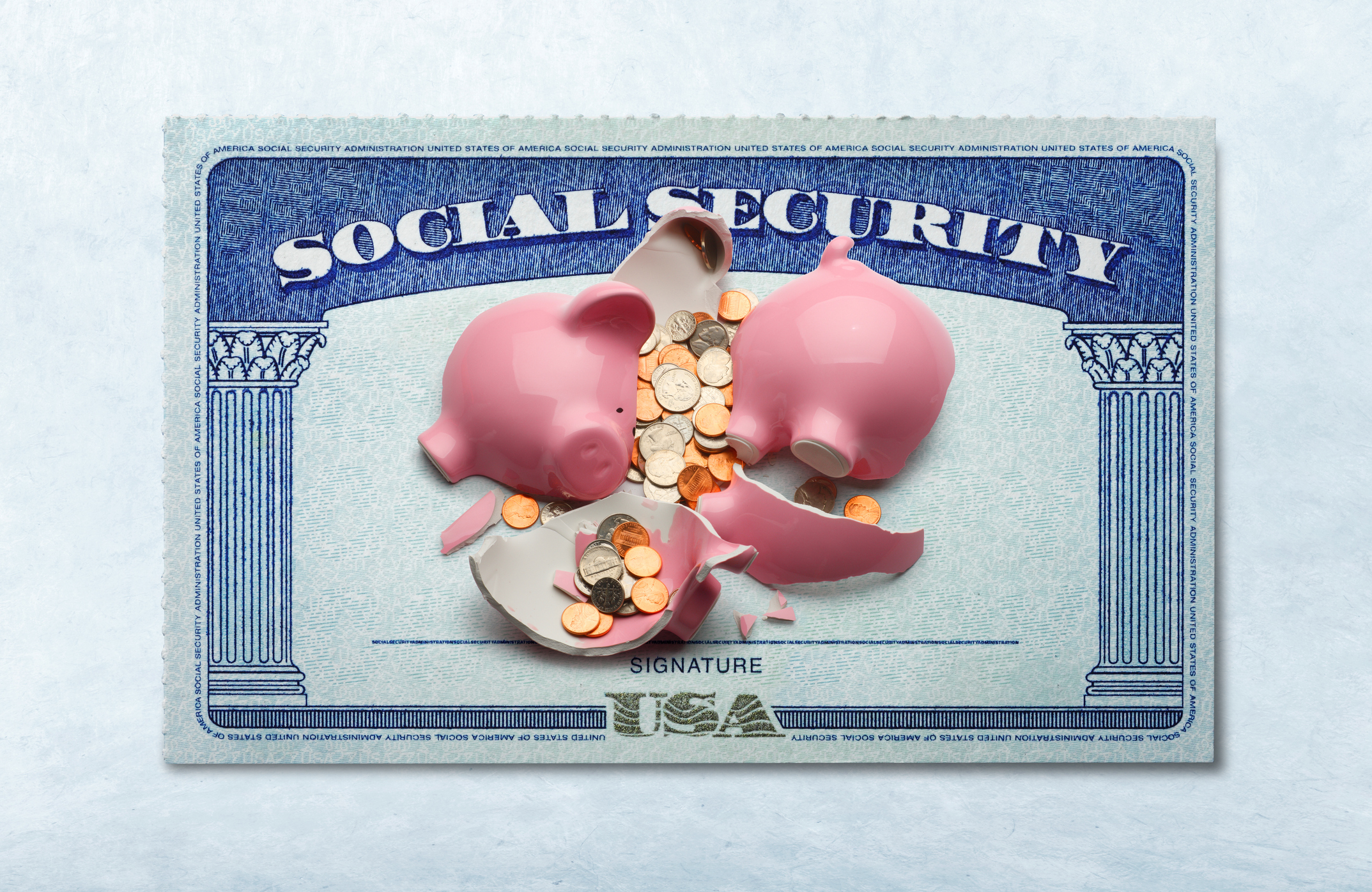 A broken piggy bank with coins inside on top of a Social Security card.
