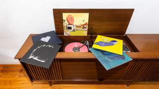 Colourful vinyl records displayed across a wooden record console