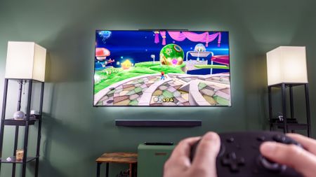 A person holding a controller playing Super Mario Galaxy using the Genki Covert Dock 3