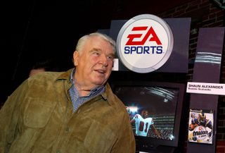 John Madden poses in front of an EA Sports logo