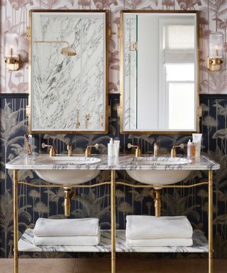 bathroom with same wallpaper, two colorways, double sinks, double mirrors, brass hardware,