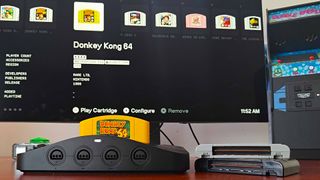 Analogue 3D connected to monitor with yellow Donkey Kong 64 cart inserted and matching library entry on screen.
