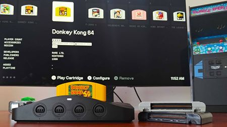 Analogue 3D connected to monitor with yellow Donkey Kong 64 cart inserted and matching library entry on screen.