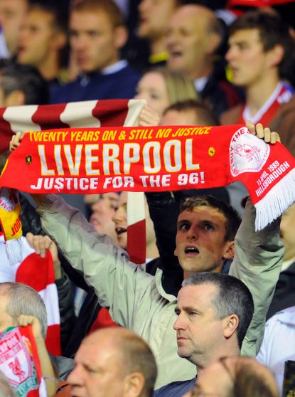 Liverpool fan holds up a justice for the 96 banner