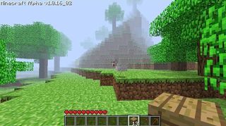 A Minecraft alpha world in a grassy hill. A dense fog begins not far from the player and just beyond it stands Herobrine, a character that looks like Steve with white eyes.
