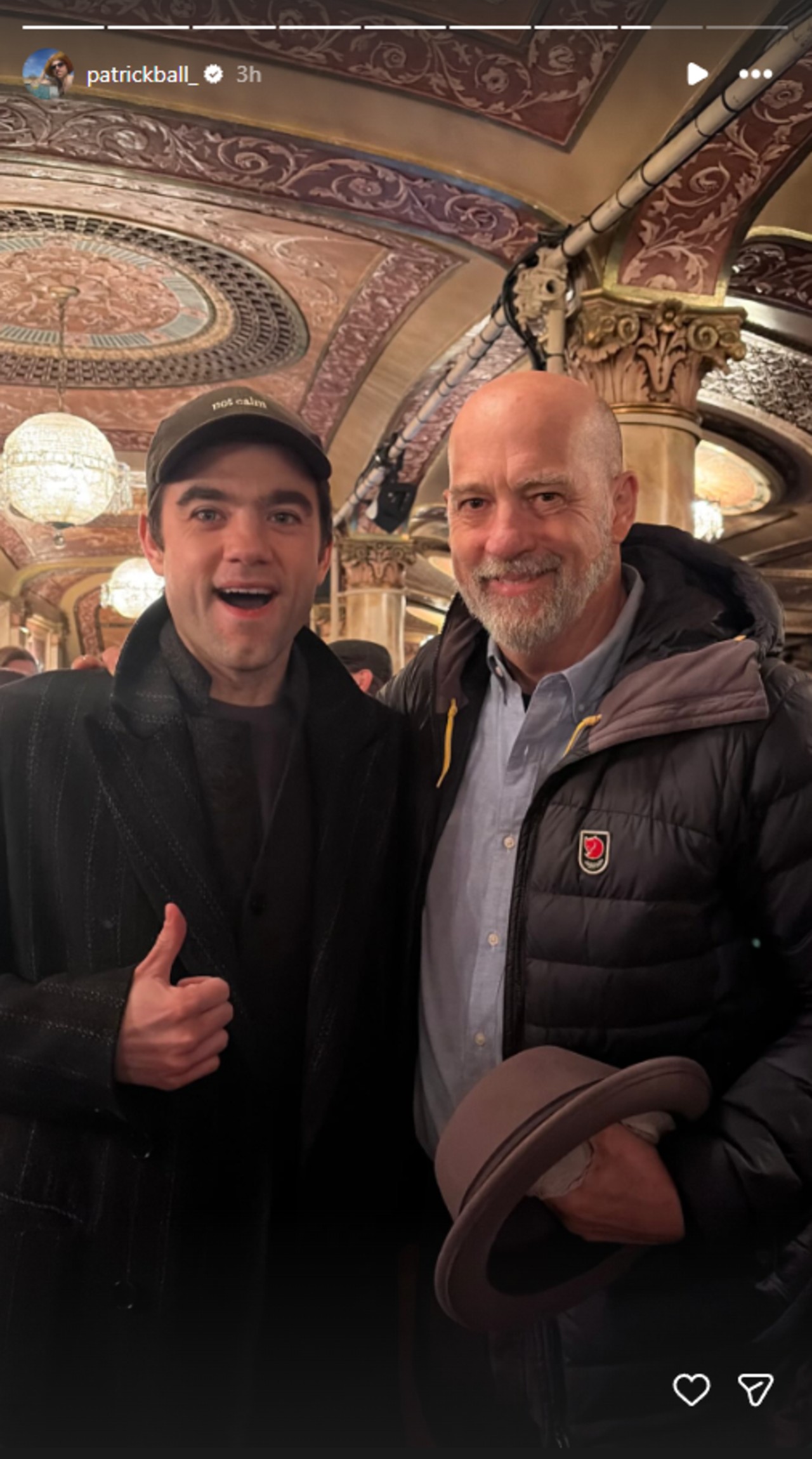 From left to right: Patrick Ball smiling and giving a thumbs up with his left hand while standing with Anthony Edwards who is holding a hat in his right hand.