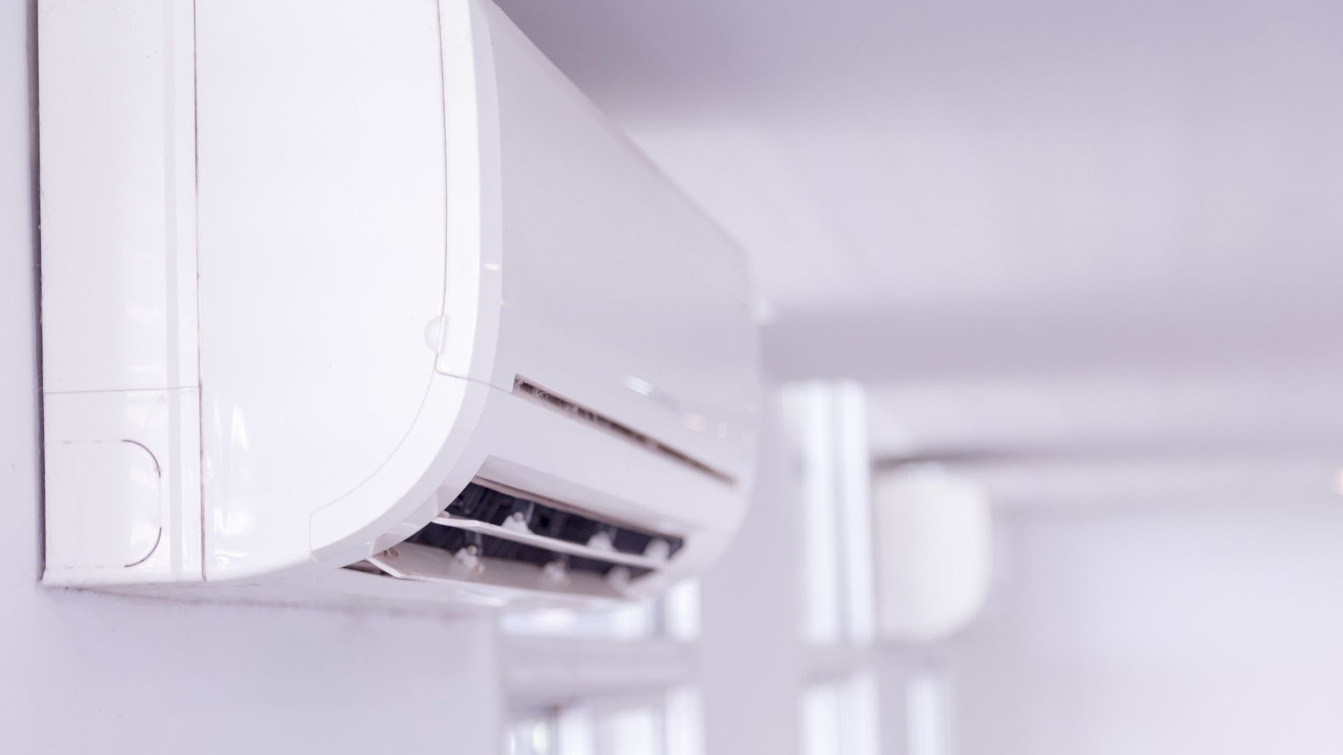 air conditioning unit on a wall in a white room to support a guide comparing an Air conditioner Vs dehumidifier