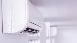 air conditioning unit on a wall in a white room to support a guide comparing an Air conditioner Vs dehumidifier
