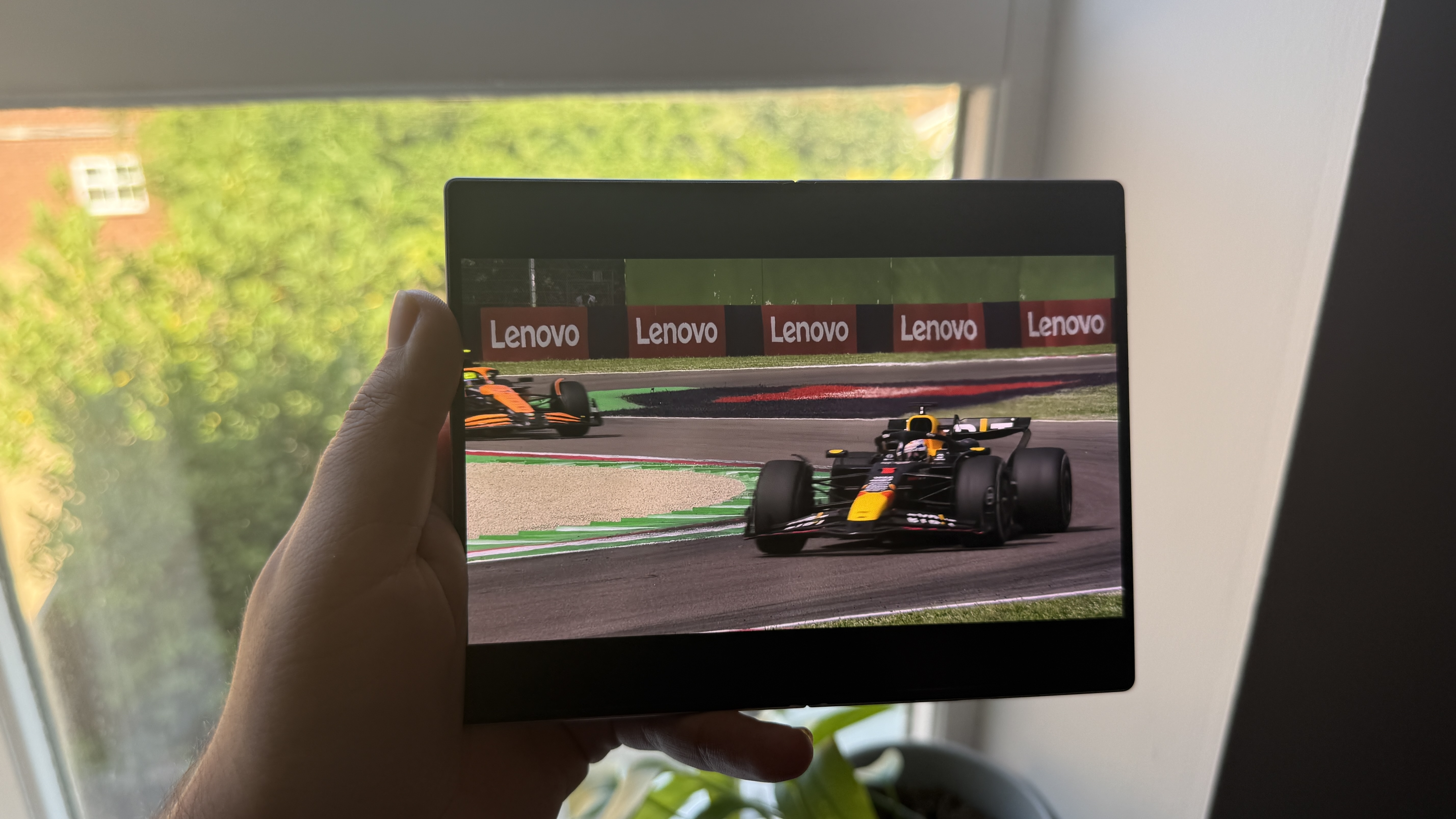 A Samsung Galaxy Z Fold 8 smartphone in hand with Netflix's Drive to Survive on screen