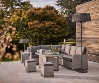 outdoor corner sofa, fire pit table and lamp on a patio