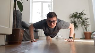 Man performing push-up, his face screwed up with effort