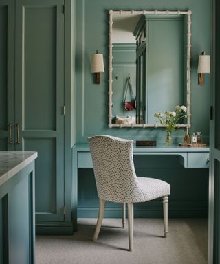 small blue color drenched dressingroom with a small deck and a large white bamboo style mirror