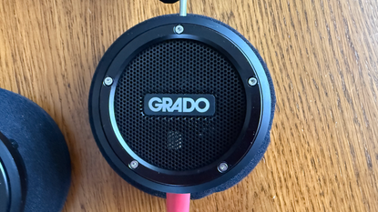 Grado Signature S750 headphones shot from above to show the grado logo. The headphones are on a wooden surface