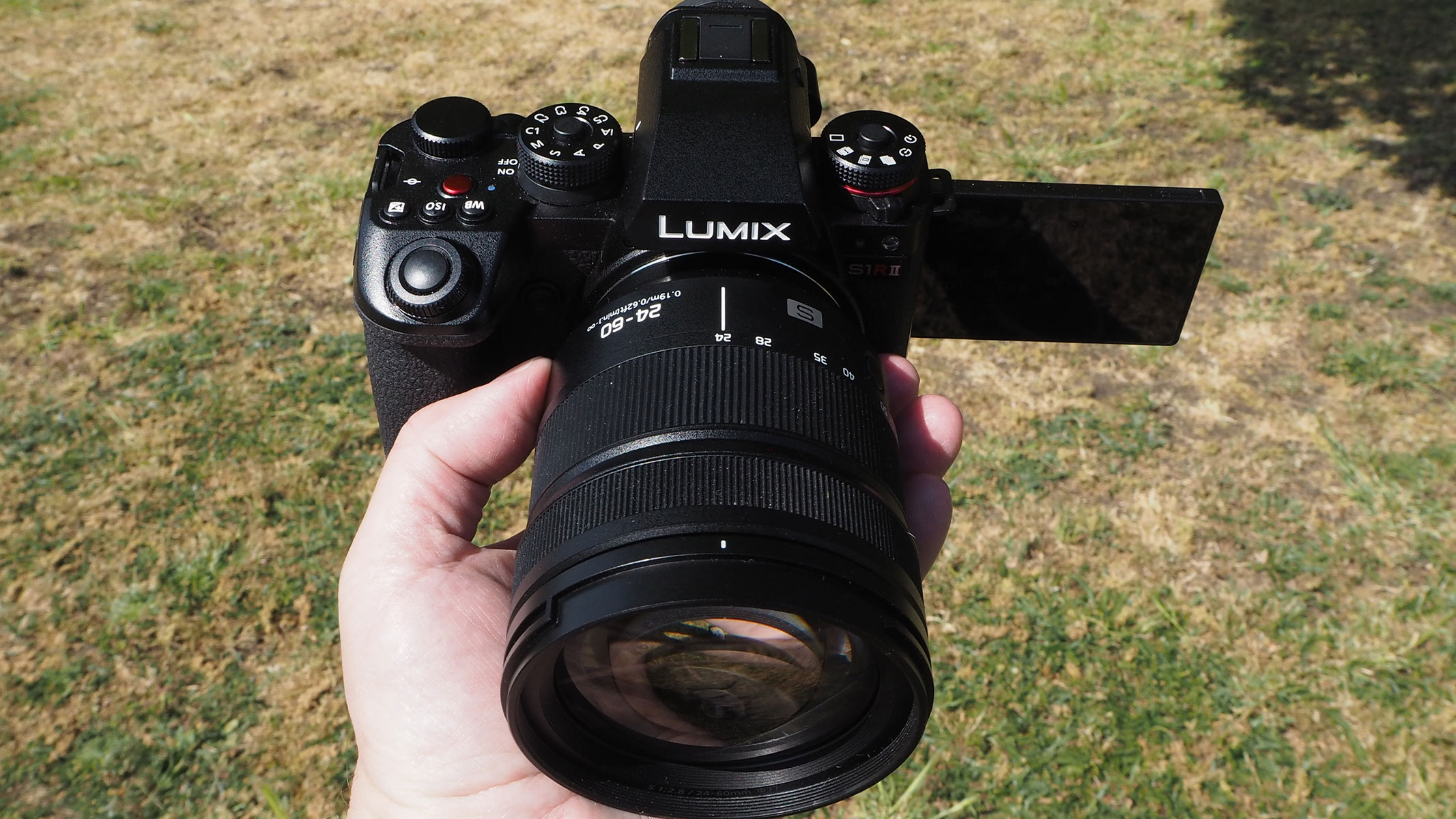 Reviewer holding the Panasonic Lumix S1R II with the screen extended to the side.