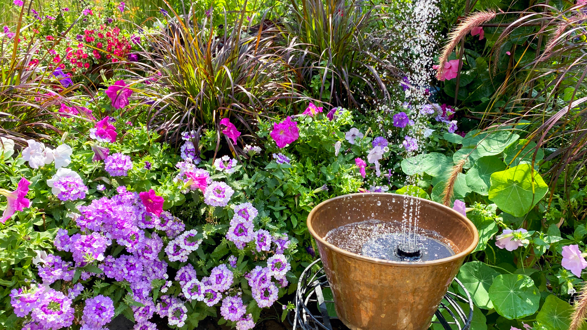 Garden water feature made from a container and a solar fountain or solar-powered floating water fountain