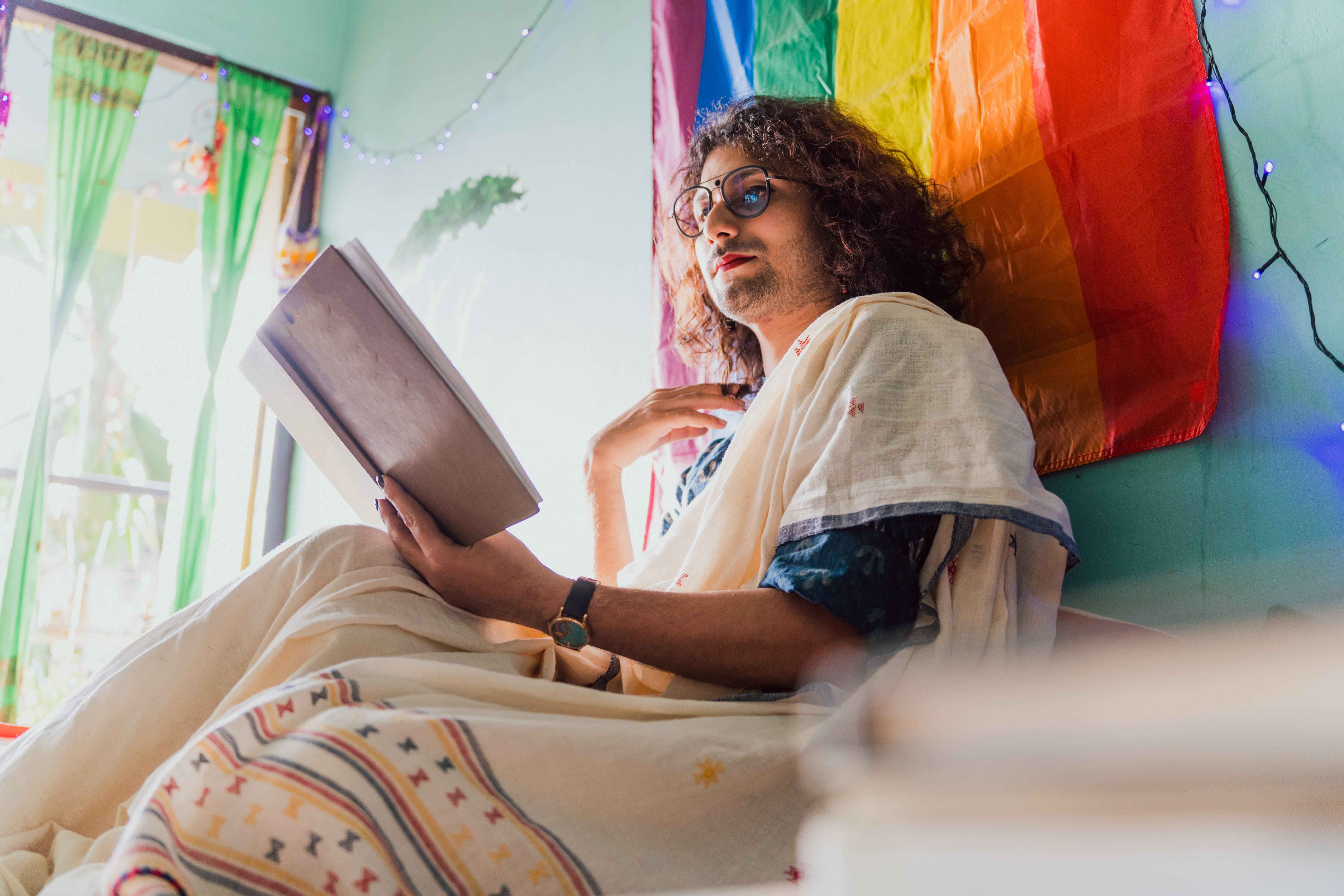 Một người chuyển giới không phải nhị phân đọc sách trong phòng khách của họ