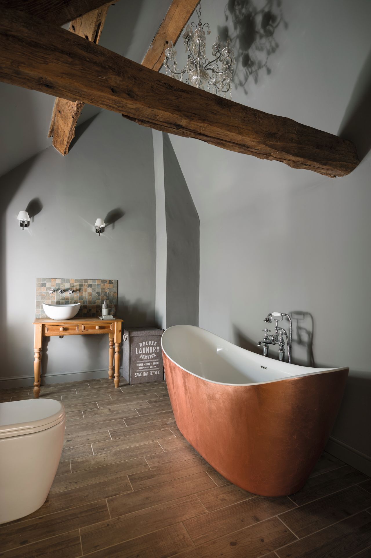 bathroom with brass bath and vaulted ceiling in cottage