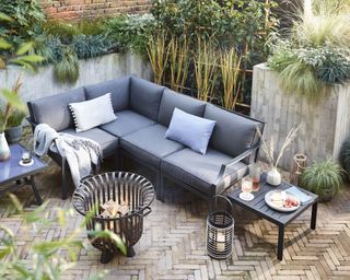grey corner sofa on a patio with a fire pit