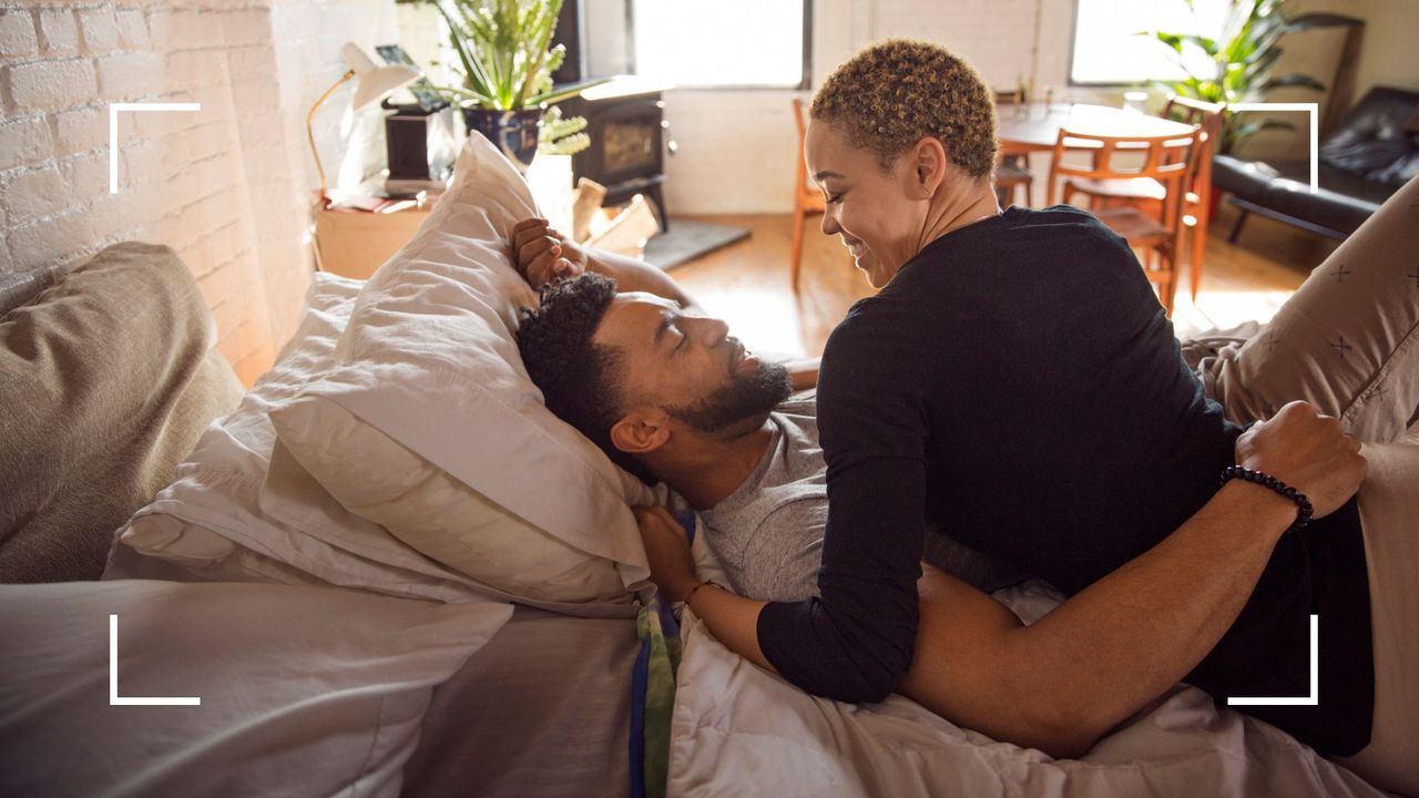 Couple lying romantic in bed looking into each other&#039;s eyes, representing yoga sex positions