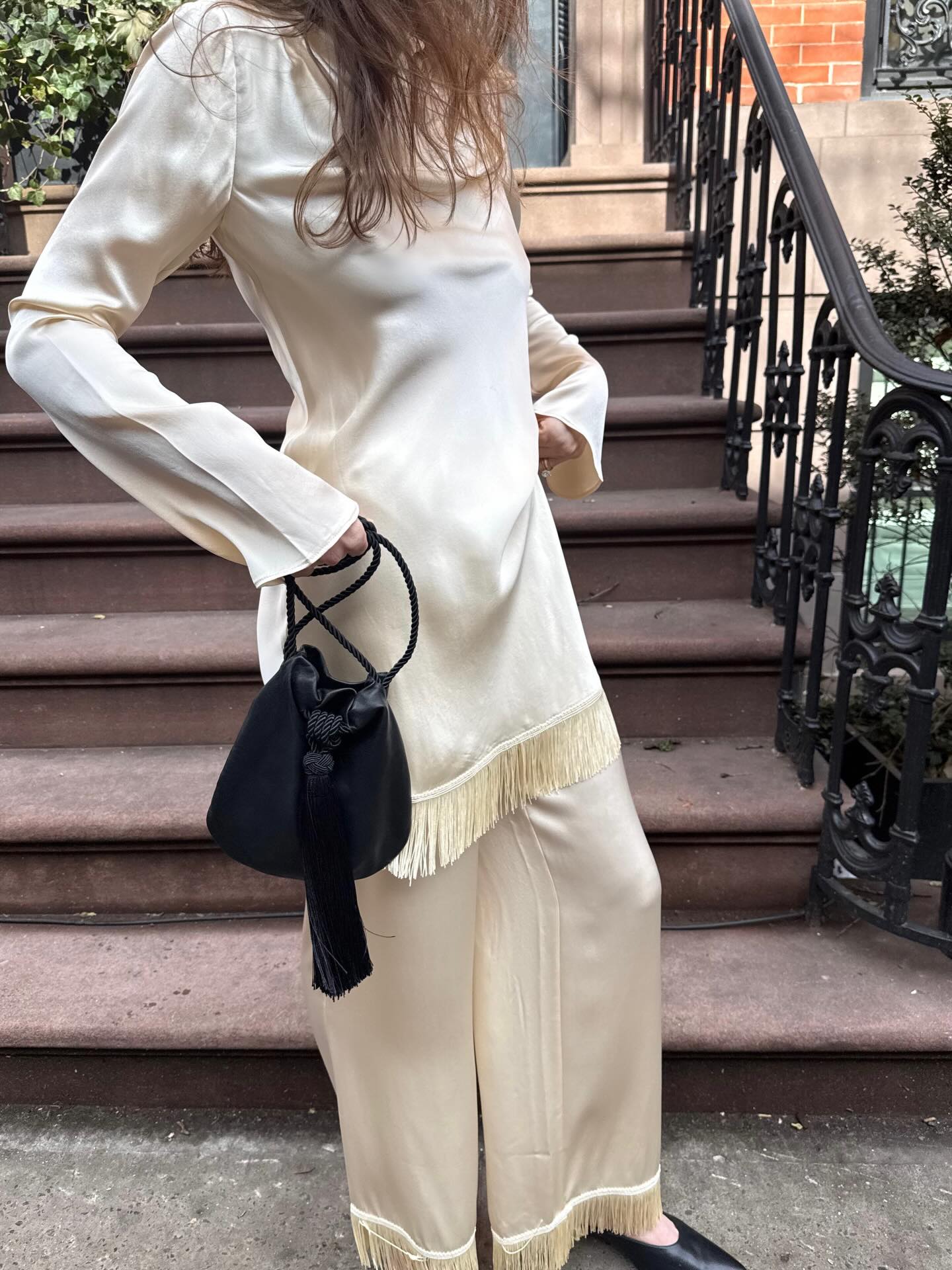 An image of @kathleenfialka wearing trassel trousers, one of the best anti-jeans summer trouser trends with a tassel top.