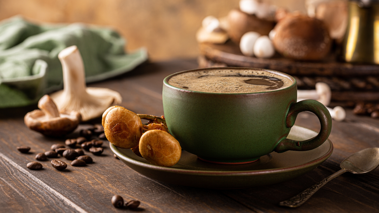 Mushroom coffee in a green cup on a wooden table