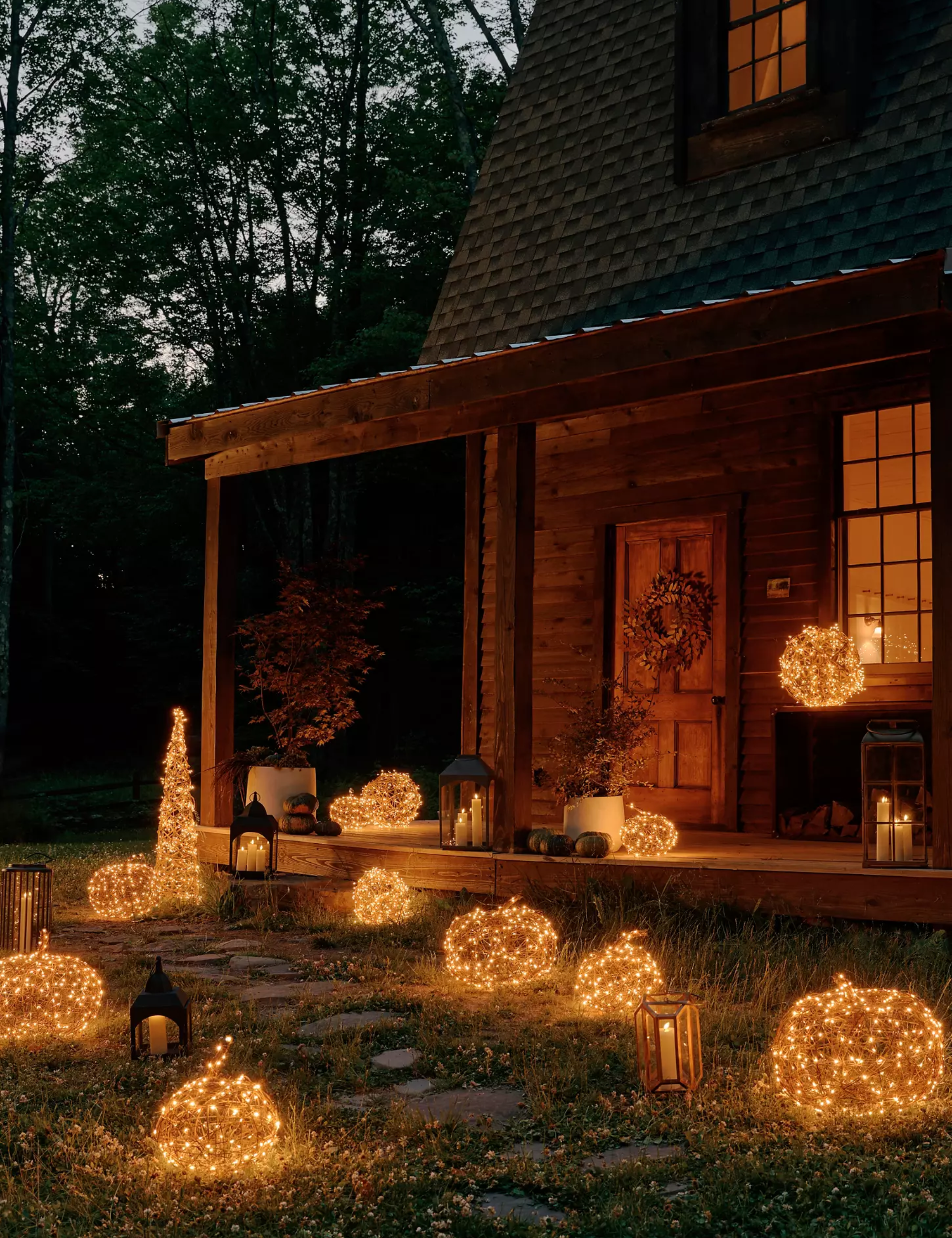 Outdoor walkway lined with illuminated LED pumpkins, witch hats, and lanterns