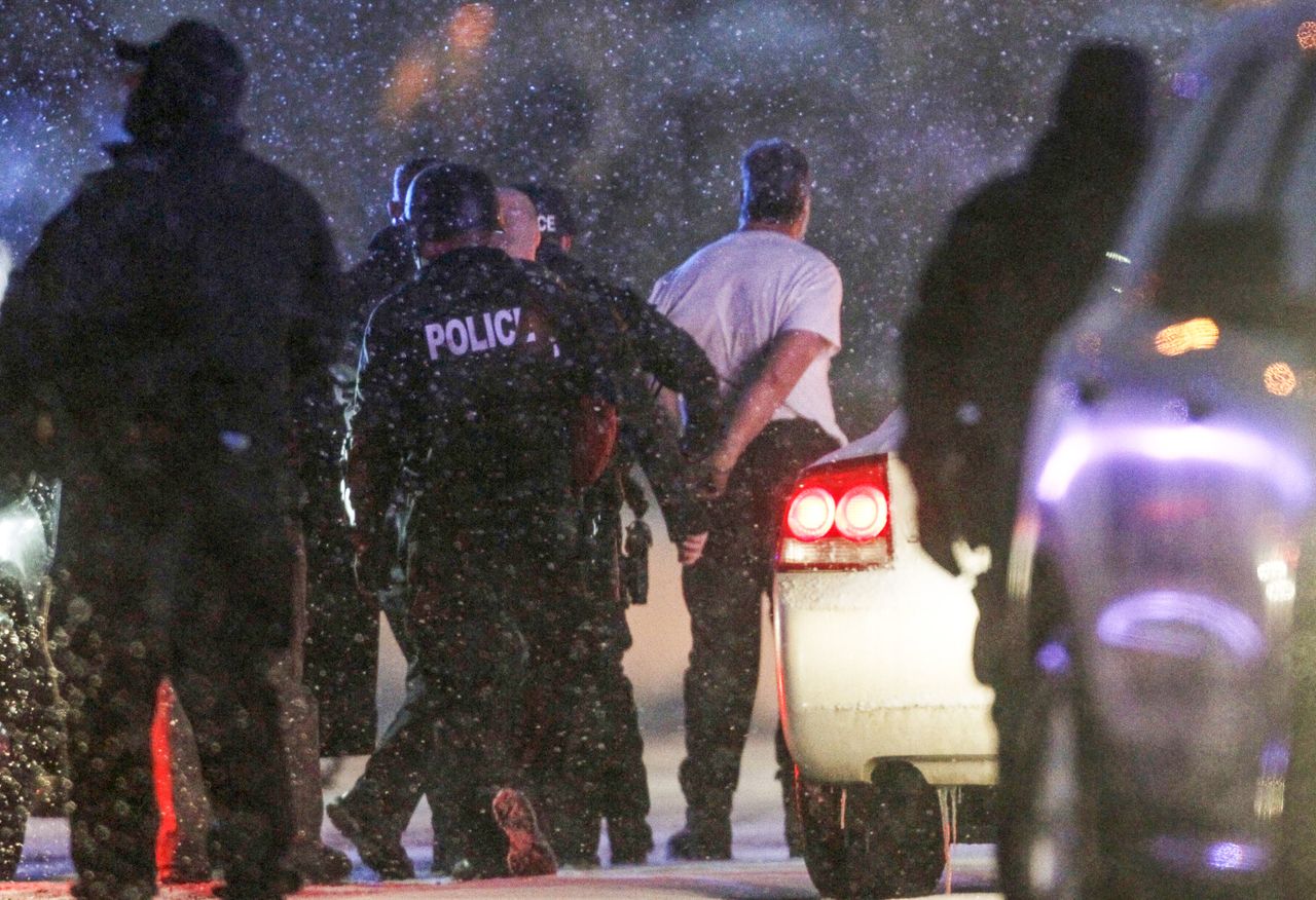 he handcuffed suspected gunman at the Planned Parenthood clinic is moved to a police vehicle in Colorado Springs, Colorado.