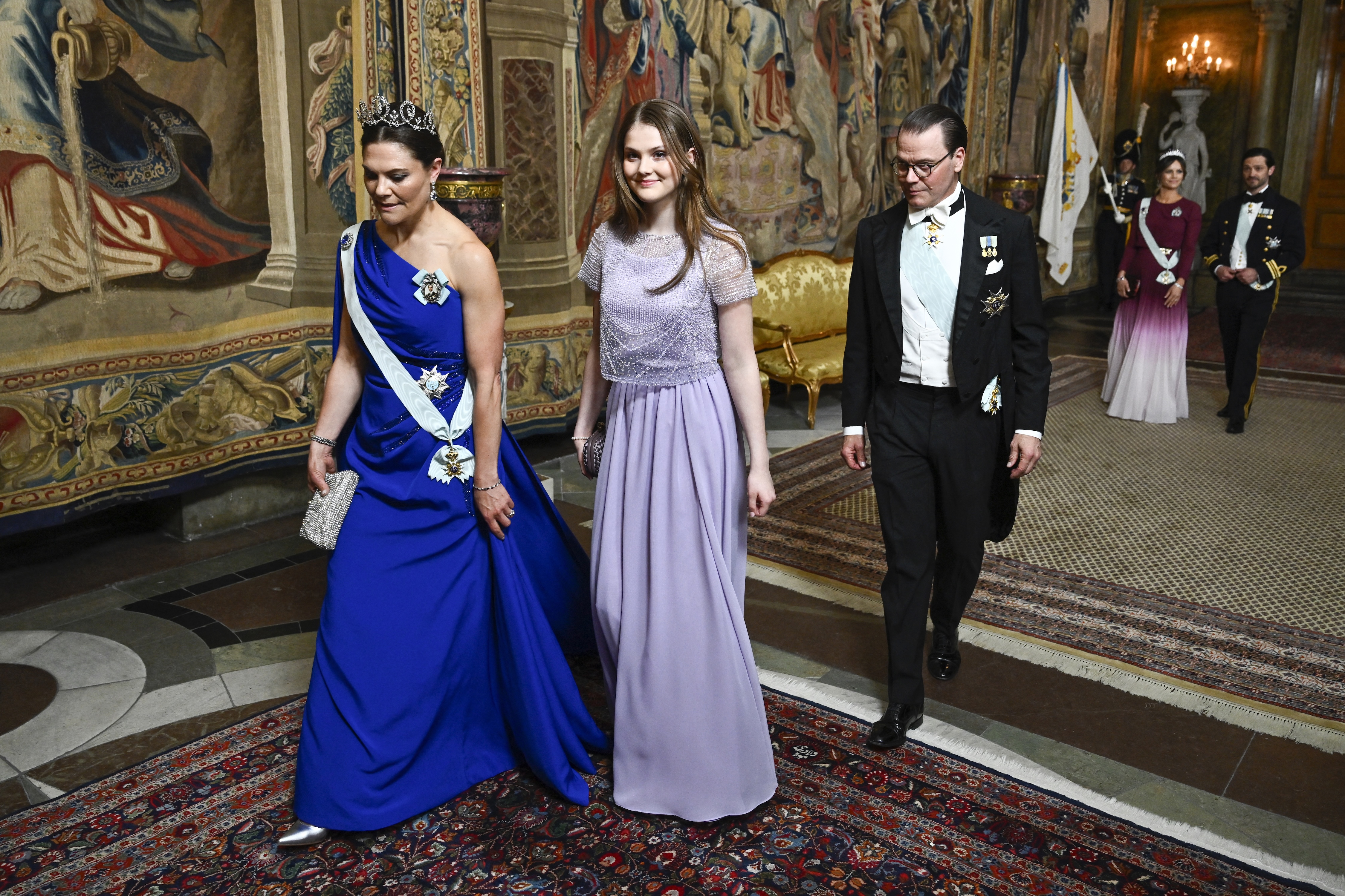Crown Princess Victoria, Princess Estelle and Prince Daniel walking into a banquet