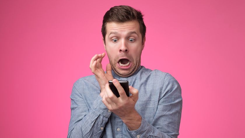 Man looking in fear at a phone, with a pink background