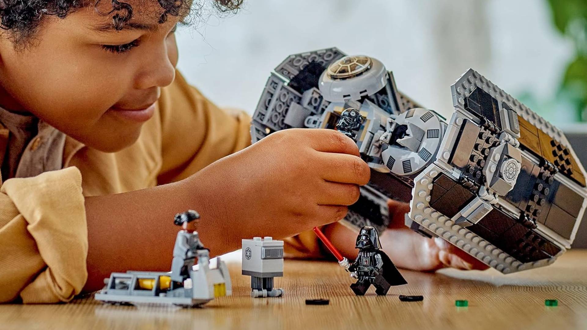 Kid playing with Lego TIE Bomber set