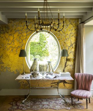 Gold mural in a bathroom with a large freestanding tub