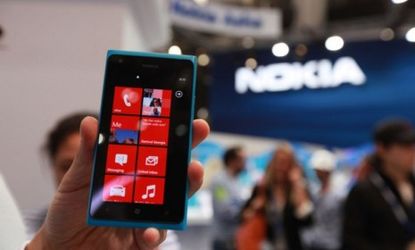 The Nokia Lumia 900 phone at the Mobile World Congress in Barcelona: The cash-strapped Nokia will slash its Lumia smartphone prices to try to drive sales.