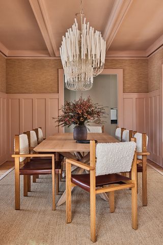 modern dining room with pink walls and large chandelier
