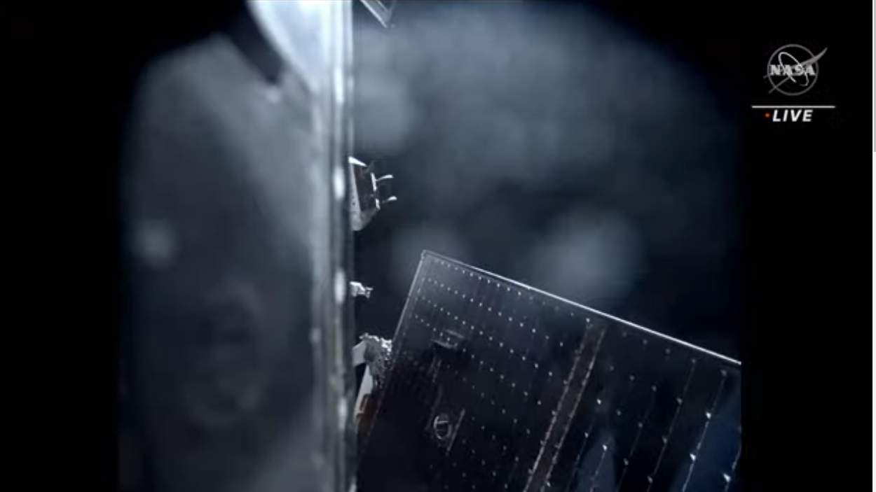 view of the side of a spacecraft and solar panels in space