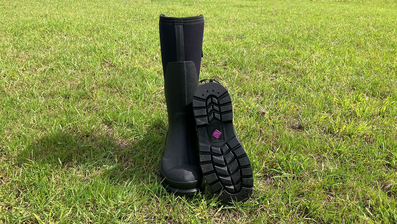 Muck Boot Women&rsquo;s Chore Adjustable Tall Boots front view in field with one showing footbed