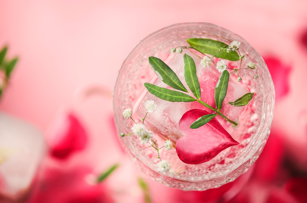 Glass with drink and rose petal